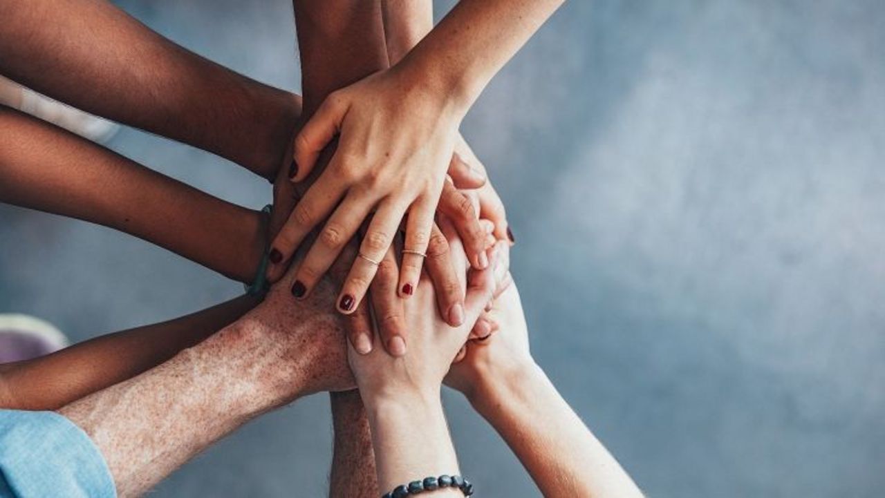 Hände in Gruppe Hande übereinandergelegt in Gruppe